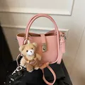 Sac seau en cuir rose à grain de litchi avec fermoir rotatif et breloque ours en peluche - Avec Pendentif / Rose