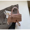 Hellrosa Leder-Handtasche mit dekorativen Riemen und silberner Metallschnalle für Damen - Einheitsgröße / Rosa