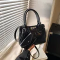 Glänzende schwarze Handtasche mit Silberdrehverschluss und Mini-Anhänger-Etui - Schwarz