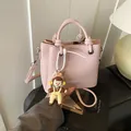 Rosafarbene Beuteltasche mit Litschi-Struktur, Doppelgriffen und niedlichem Anhänger - Mit Anhänger / Lila