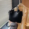 Bolso tipo cubo negro con textura de lichi, asa de nudo y correa fina ajustable - Sin colgante / Negro