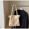 Détail du sac cabas beige montrant le cuir souple et les perles métalliques décoratives - Sans Pendentif / Jaune