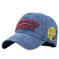 Dettaglio del ricamo Discovery e dello scudetto giallo sul cappellino blu lavato - Regolabile / Blu navy