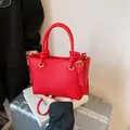 Red lychee textured bucket bag with knotted handles and adjustable shoulder strap - No Pendant / Red