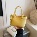 Yellow litchi leather bucket bag with creative knotted handle and adjustable strap - No Pendant / Yellow
