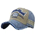 Detailed macro view of vintage distressed 1969 embroidery on khaki and blue baseball cap - Coffee and Khaki