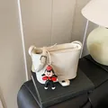 White litchi pattern bucket bag with cartoon pendant and adjustable shoulder strap - With Pendant Style / Off White