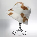 Fleece bucket hat with brown cow pattern on minimalist black metal display stand - M / Cow Pattern / White