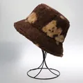 Deep brown plush bucket hat with beige bear pattern on a display stand - M / Bear Pattern / Camel
