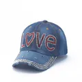 Detail of blue denim baseball cap featuring LOVE rhinestone letters and silver studded brim - Blue-LOVE