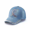 Close-up of pink and silver rhinestones on a light blue washed denim baseball cap - Light Blue Ribbon Symbol