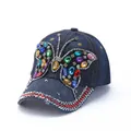 Navy denim baseball cap with a colorful rhinestone butterfly and metal stud accents - Dark Blue Heavy Beaded Butterfly