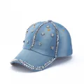 Detail of light blue denim baseball cap with silver skull studs and rhinestone trim - Light Blue Silver Skull