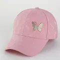 Vue détaillée de la casquette rose en dentelle avec broche papillon dorée scintillante - Ajustable 56-60cm / Rose