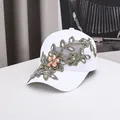 Détail de broderie en dentelle florale et strass colorés sur une casquette blanche - 56-60cm / Broderie Florale Blanche