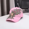 Détail de la casquette rose avec broderies florales dorées et accents de strass ambrés - 56-60cm / Broderie de Fleurs Roses