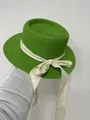 Detail of green straw boater hat with a cream ribbon bow held against a neutral wall - 56-58cm / Beige Ribbon Bow (040S) / Fruit Green
