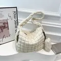 Minimalist beige quilted cloud tote bag with matching round coin purse on a display stand - White