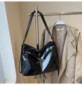Detail van een zwarte glanzende leren shopper met metalen draaisluiting op standaard - Zwart