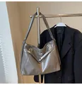 Detail van grote metallic tote bag met zilveren draaisluiting en glanzende ledertextuur - Olifantsgrijs