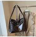 Detail van een glanzende vintage draagtas met zilveren gesp en glad PU-leer - koffiekleur
