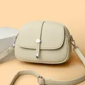 Minimalistische beige Satteltasche aus Leder mit Klappverschluss und Schultergurt - Weiß