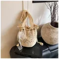 Detailed macro view of the hollow crochet knit pattern and pearl bow charm on the bucket bag - With Lace Bow And Pearl Pendant / Off-white with Pendant