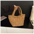 Detail of brown quilted bucket bag featuring white bow embroidery and padded handles - No Pendant / Khaki