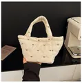 Detail of quilted beige bucket bag with brown bow embroidery and a soft puff texture - No Pendant / Off White