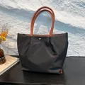 Borsa tote in nylon impermeabile con manici in pelle marrone e bottone dorato - Nero