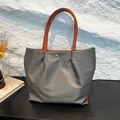 Borsa tote in nylon impermeabile grigio scuro con design a pieghe e manici in PU - Grigio