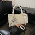 Sac à main rectangulaire blanc ivoire avec breloque nœud et finitions métalliques argentées - Avec Pendentif / Blanc Cassé
