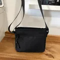 Versatile black nylon crossbody bag featuring woven zipper pulls and adjustable strap - Black