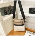 Detailed view of canvas crossbody bag with three-color stitching and double zippers - Off White
