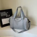 Light grey nylon travel bag with adjustable strap and waterproof sports design - Gray