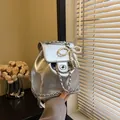 Metallic silver mini backpack with pearl bow charm and chain strap in casual style - With Pendant / Silver