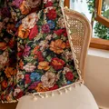 Tapiz tejido vintage de flores con borlas blancas colocado sobre una silla de ratán - Estilo de Gancho / 150x45cm / Rosa Colorida