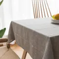 Detailopname van grijs linnen tafelkleed met wit geometrisch kruissteek borduurwerk erop - Geborduurde Grijze Raster Stijl