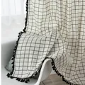 Close-up of gray and white geometric cotton linen curtain with black tassel edge trim - White Black Grid - Hook Type