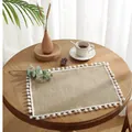 Rectangular jute placemat with white pom-pom trim on a rustic wooden dining table - 30x40cm / Natural Jute With White Pom Poms