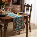 Chemin de table bohème aux motifs de feuilles bleu-orange avec pompons tissés - Papillon & Fleur