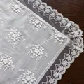 Close-up of white 3D floral embroidery on lace tablecloth with delicate wavy edges - 60x60cm / White Floral Embroidery (Lace Edge)