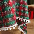 Close-up of red and green plaid Christmas tablecloth with snowflake print and pom-poms - 100x140cm / Red and Green Plaid with Snowflake and Pom-poms