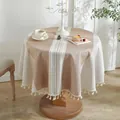 Detalle de mantel redondo de jacquard con texturas tejidas y elegantes flecos de borlas - Diámetro 140 / Línea Decorativa Café