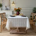 Close-up of elegant beige lace tablecloth featuring floral hollow embroidery and tassels - Beige Floral Pattern (Tassel Style)