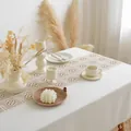 Detail of bohemian hollow crochet table runner with tassels on a white cotton cloth - Grid Stitching Tassels Small Square (5140)