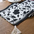 Camino de mesa moderno de jacquard floral en blanco y negro con borlas en mesa de madera - 35X140cm / Flor negra