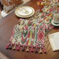 Dettaglio del runner da tavolo in tessuto spesso con motivi geometrici colorati e nappe - Jacquard Etnico con Nappine Rosse