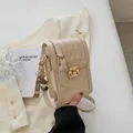 Beige quilted crossbody bag with golden buckle and a cute bear keychain accessory - White