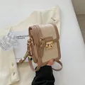 Beige and brown quilted crossbody phone bag with metal clasp and bear charm - White & Khaki